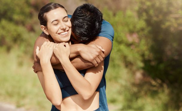 Affectionate young interracial couple taking a break from exercise and run outdoors. Loving man hugging arm around woman while motivating each other towards better health and fitness. - 写真・画像