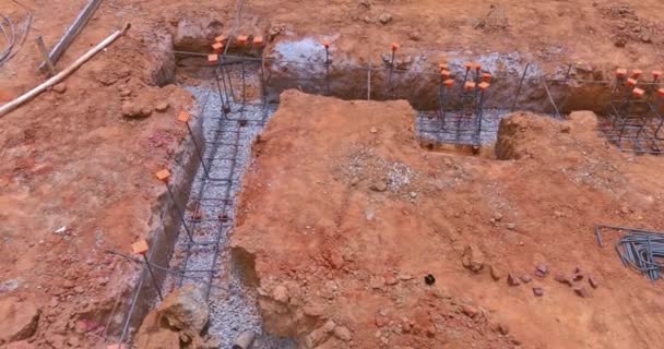 Η τάφρος ανασκαφής κάτω από μια τσιμεντένια βάση για ένα νέο σπίτι σε ένα εργοτάξιο - Πλάνα, βίντεο