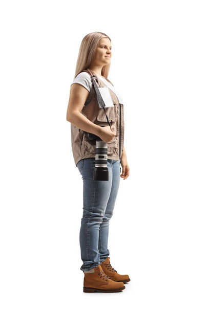 Full length shot of a female photo journalist carrying a camera on her shoulder isolated on white background - Fotografie, Obrázek