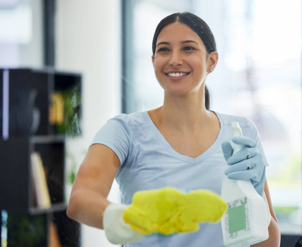 Porträt einer fröhlichen gemischten Hausangestellten mit einem Tuch an einem Fenster. Eine hispanische Frau genießt es, in ihrer Wohnung Hausarbeiten zu erledigen. - Foto, Bild