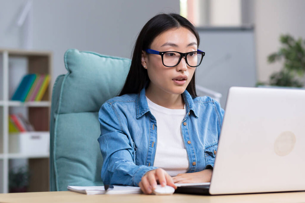 aziatische freelancer vrouw werken met laptop in huis kantoor op afstand, zakenvrouw dragen casual kleding. - Foto, afbeelding