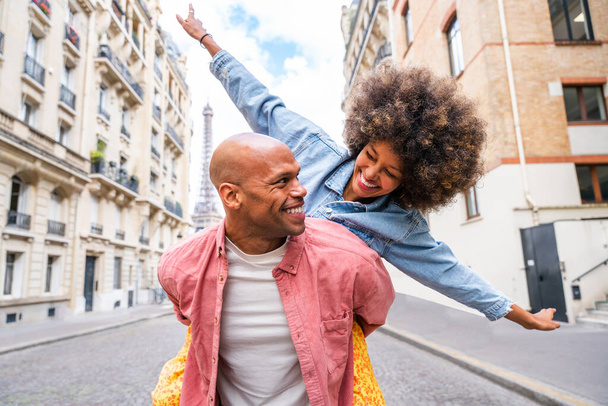 Black cheerful happy couple in love visiting Paris city centre and Eiffel Tower - African american tourists travelling in Europe and dating outdoors - 写真・画像