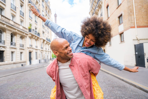 Black cheerful happy couple in love visiting Paris city centre and Eiffel Tower - African american tourists travelling in Europe and dating outdoors - Photo, Image