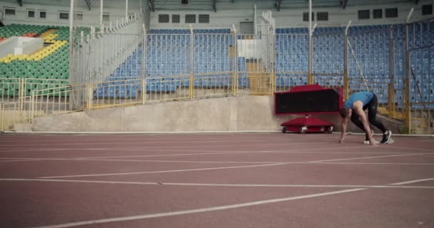 Sportsman jumping over obstacles while running on racetrack on stadium.Slow Motion - Video, Çekim