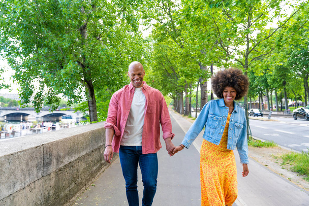 Black cheerful happy couple in love visiting Paris city centre and Eiffel Tower - African american tourists travelling in Europe and dating outdoors - Zdjęcie, obraz
