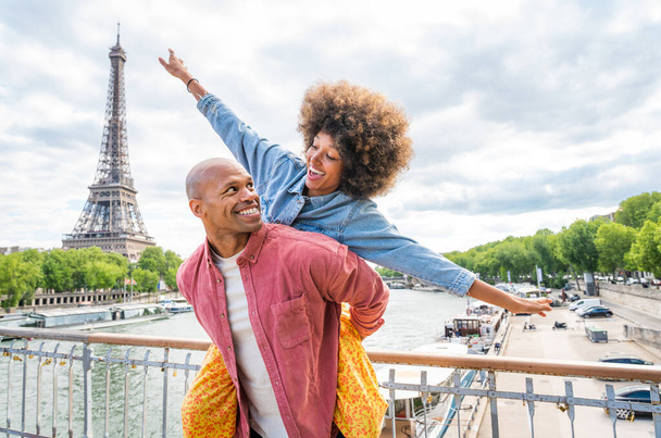 Black cheerful happy couple in love visiting Paris city centre and Eiffel Tower - African american tourists travelling in Europe and dating outdoors - Photo, image