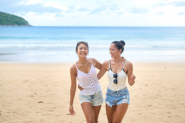Dos atractivas amigas disfrutando y relajándose en la playa, verano, vacaciones, vacaciones, concepto de estilo de vida. - Foto, imagen