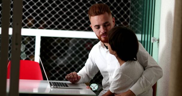 Father and son together using laptop. White dad with mixed race child helping homework. Ethnically diverse parent and kid in front of computer - Foto, Imagem