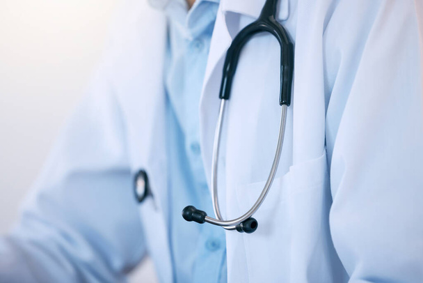 Close-up van een mannelijke arts of cardioloog die een witte labjas met stethoscoop draagt als uniform voor het werk in een ziekenhuis of kliniek. Vertrouwde arts toegewijd aan de gezondheidszorg van patiënten. - Foto, afbeelding