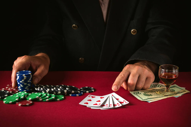 The player points with his finger at playing cards with a winning combination of straight flush. Lucky win in the poker club game. - Photo, Image