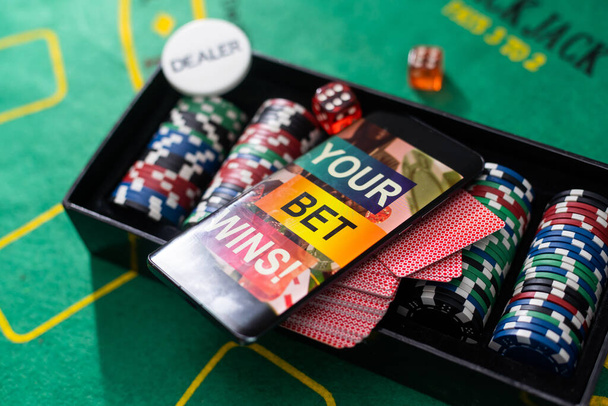 賭けの碑文はポーカーテーブルのスマートフォンで勝ちます。賭け、スポーツ賭博、ブックメーカー。混合メディア - 写真・画像