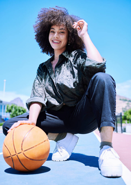 Young happy mixed race female basketball player standing on the court getting ready to play. Hispanic female basketball player enjoying a day on the court. - Foto, Imagen