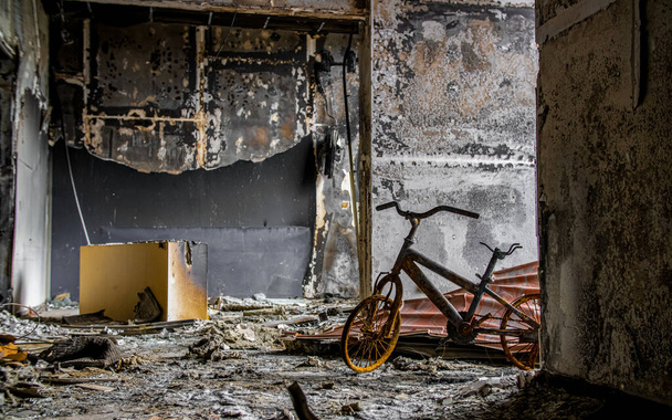 Irpin, Ukraine - 22 mai 2022 : un vélo d'enfant brûlé dans une maison détruite par les troupes russes après l'occupation de la ville. Photo de haute qualité. - Photo, image