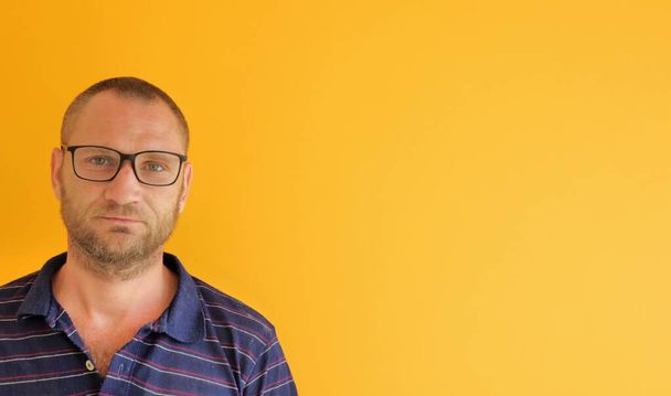 portrait of a man with glasses on a yellow background, copy space - Фото, изображение