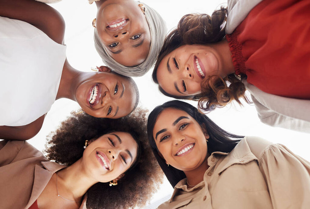Laaghoekig portret van diverse groepen zakenvrouwen, samengeklemd met hoofden in het midden. Een glimlachend etnisch team van professionele collega 's die zich verenigd, gesteund en mondig voelen. Succes in het bedrijfsleven. - Foto, afbeelding