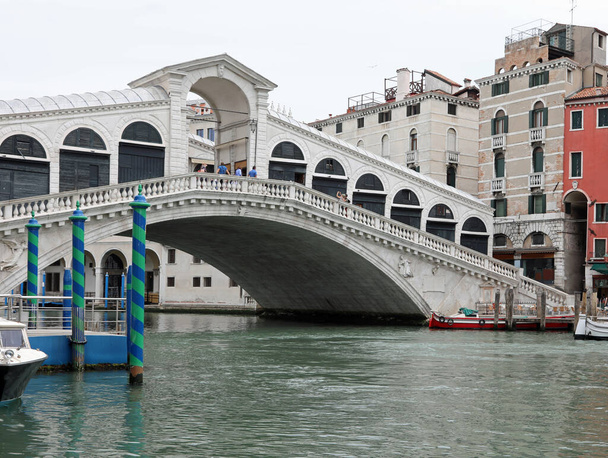 необычный вид на мост Риальто на острове Венеция с очень небольшим количеством лодок и без людей во время блокировки в Италии - Фото, изображение