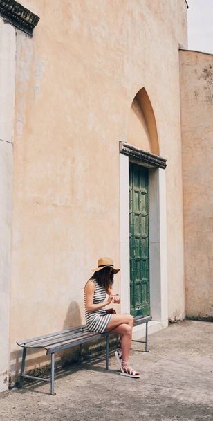 Woman using smartwatch on summer vacation in Italy. Beautiful girl checking time on wristwatch. - Fotografie, Obrázek