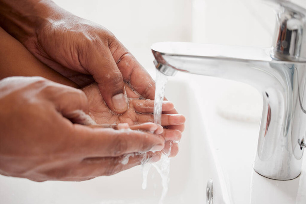未知の混合人種の父と娘が自宅のバスルームで一緒に手を洗う。アフリカ系アメリカ人の両親が娘に衛生について教えているのは. - 写真・画像