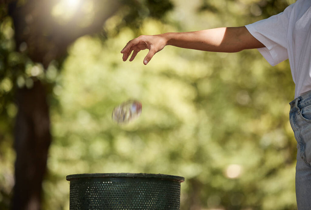 Closeup shot of a woman throwing her plastic cooldrink bottle into a bin outside in a park. The planet is our home, recycling is our responsibility. Saying goodbye to pollution and trash. Your - Foto, immagini