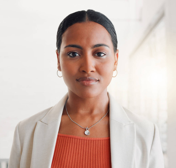 Young mixed race businesswoman standing alone in an office at work. Face of one confident hispanic businessperson looking serious standing at work. - Fotografie, Obrázek