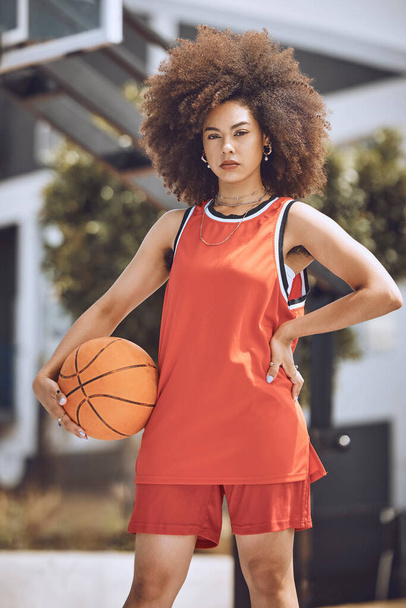 Mixed race woman posing on a basketball court. Beautiful basketball player posing confidently outside. - Фото, зображення