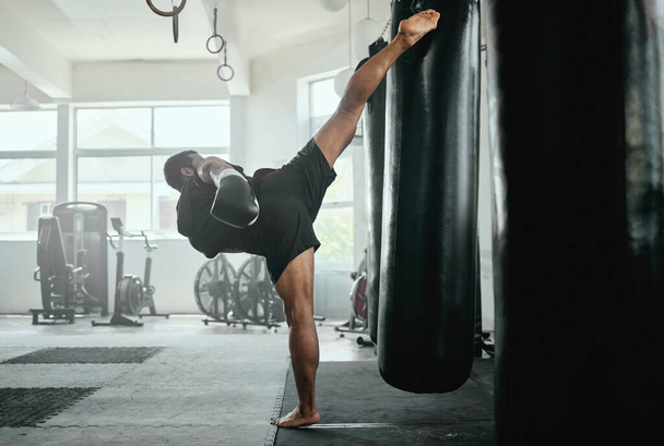 Entrenamiento de kickboxer masculino con un saco de boxeo en el gimnasio. - Foto, imagen