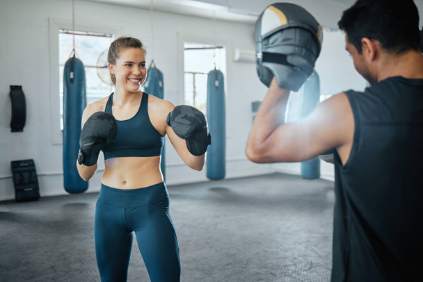 Antrenör bir kadınla antrenman yaparken boks pedlerini tutuyor.. - Fotoğraf, Görsel