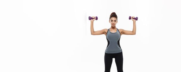 Healthy and Fitness concept - Full-length of portrait Beautiful American African lady in grey fitness clothes workout with dumbbell. Isolated on white background - Photo, Image
