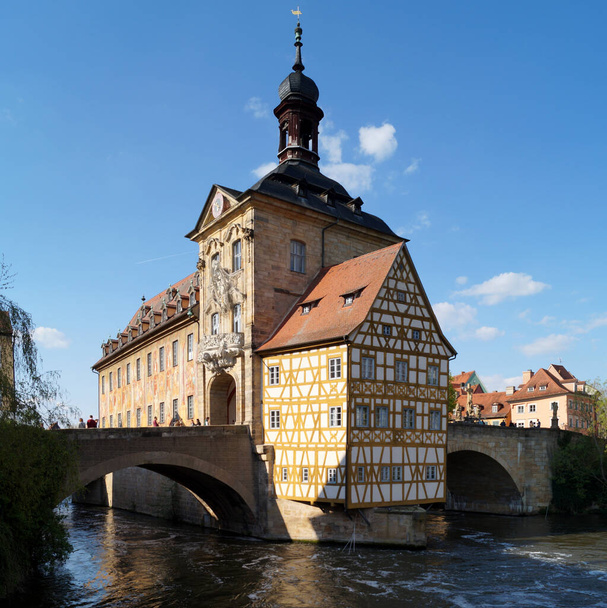 Старая ратуша, Altes Rathaus, построенная в 1386 году в середине реки Регниц, до которой можно добраться двумя мостами, Бамберг, Германия - 28 апреля 2022 года - Фото, изображение