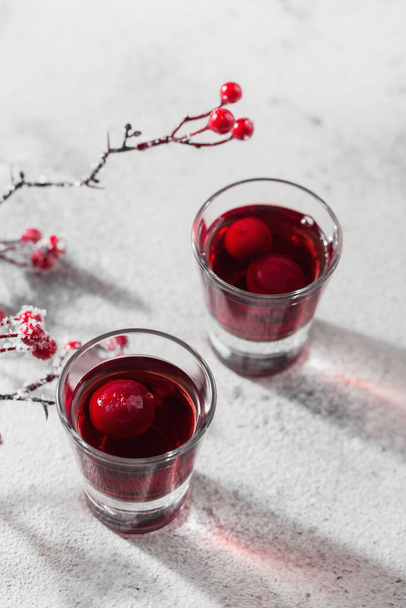 Two glasses of cherry liqueur on white background. Christmas or new year party celebration concept. Winter holidays concept. - Foto, Imagen
