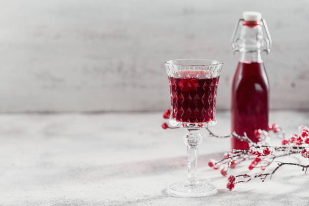 Homemade infused vodka, tincture or liqueur of red cherry on white background. Berry alcoholic drinks concept. - Фото, изображение