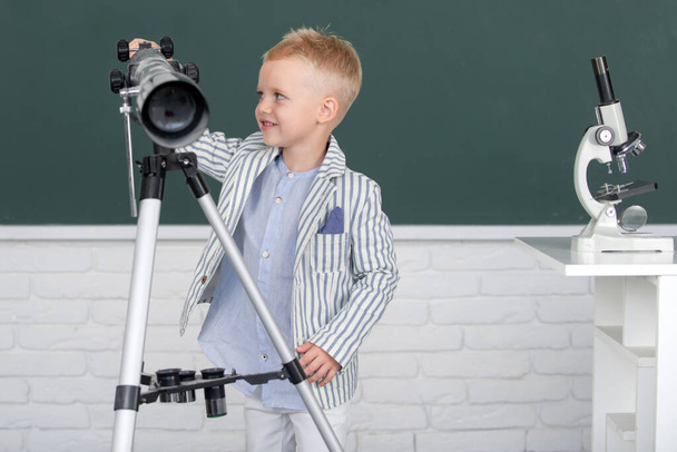 Dzieciak w szkole z teleskopem uczący się astronomii w szkole - Zdjęcie, obraz
