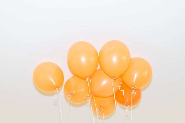 Ένα μάτσο πορτοκαλί μπαλόνια σε λευκό φόντο.Κάτω όψη. - Φωτογραφία, εικόνα