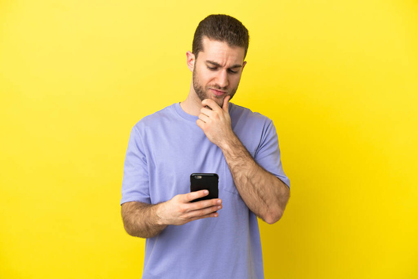 Handsome blonde man over isolated yellow background thinking and sending a message - Φωτογραφία, εικόνα