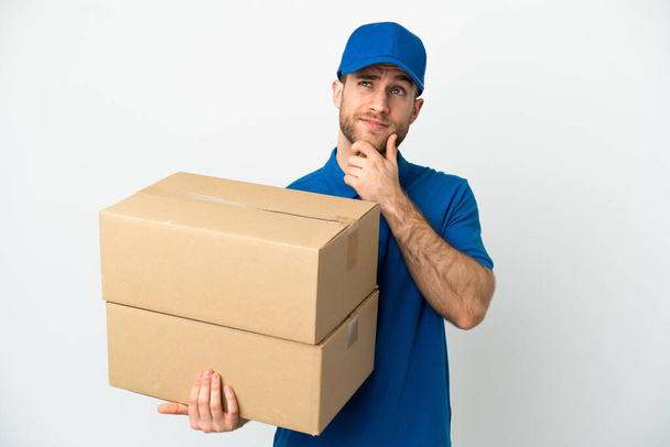 Delivery man over isolated white background and looking up - Photo, Image