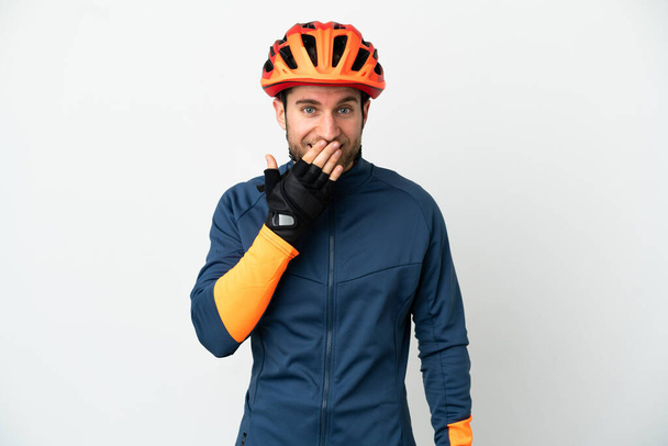 Young cyclist man isolated on white background happy and smiling covering mouth with hand - Photo, image