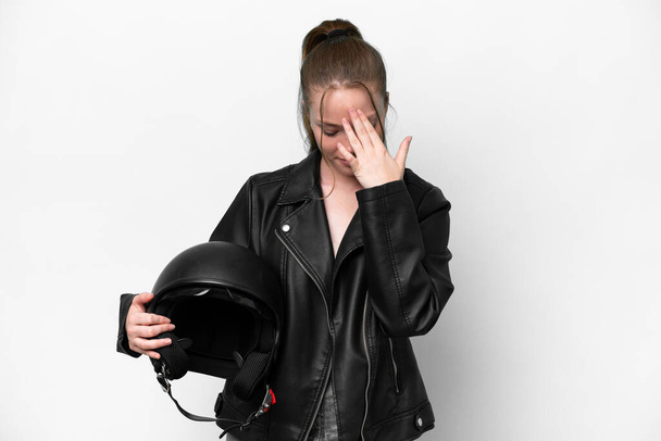 Молода біла дівчина з мотоциклетним шоломом ізольована на білому тлі з втомленим і хворим виразом
 - Фото, зображення