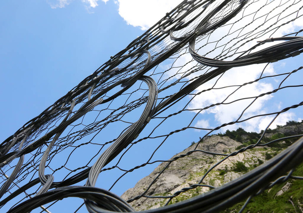 Metal koruma ağı kayaların yollara düşmesini ve dağ yürüyüşçülerinin katettiği patikalara düşmesini önlemek için. - Fotoğraf, Görsel