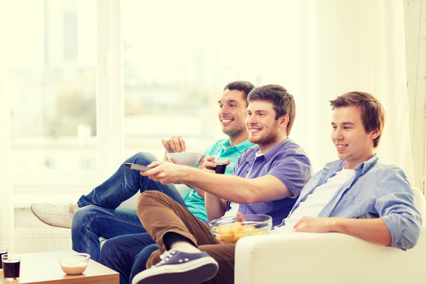 smiling friends with remote control at home - Zdjęcie, obraz