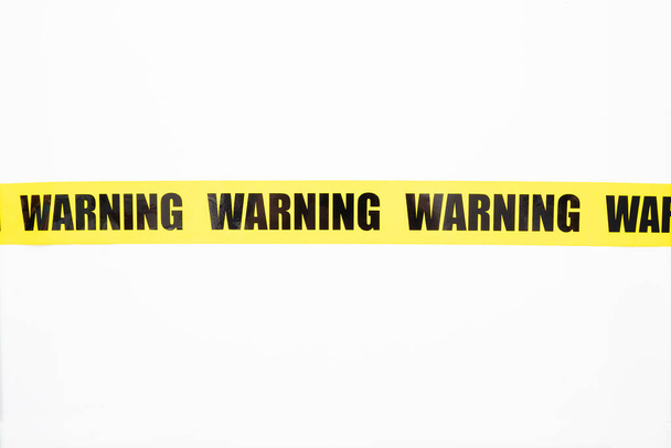 Yellow warning tape isolated and cutout on white background. Risk and accident concept - Photo, Image