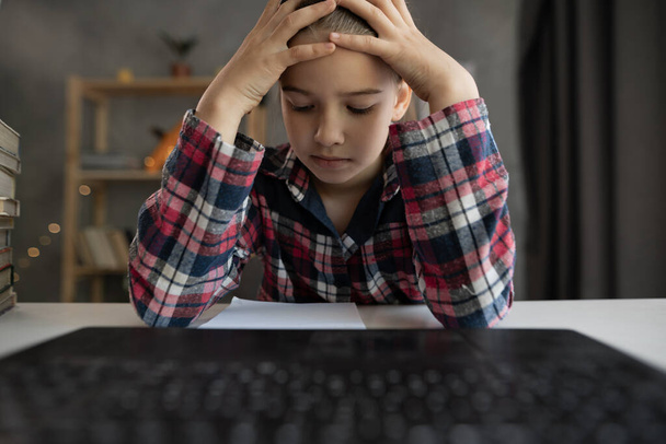 kaukaskie dziecko dziewczynka mają ból głowy studiuje online na komputerze z domu, przy użyciu laptopa w domu, punkt widzenia kamery. Zdenerwowany nastolatek ma lekcję online - Zdjęcie, obraz