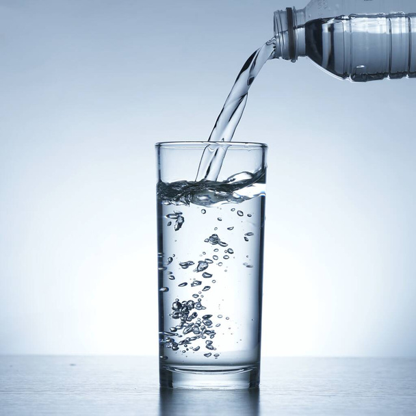 Изображение заливки воды из бутылки в стакан - Фото, изображение