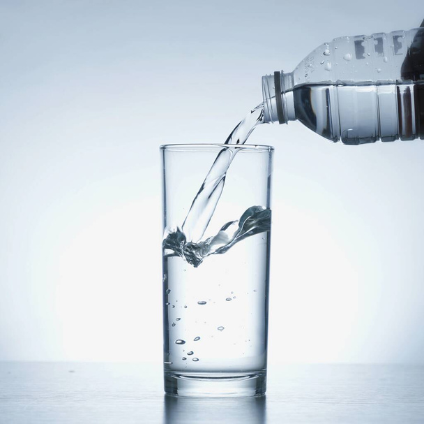 Изображение заливки воды из бутылки в стакан - Фото, изображение