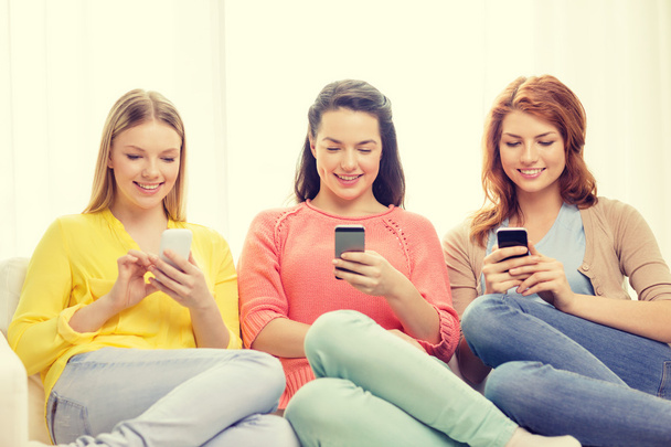 smiling teenage girls with smartphones at home - Photo, image