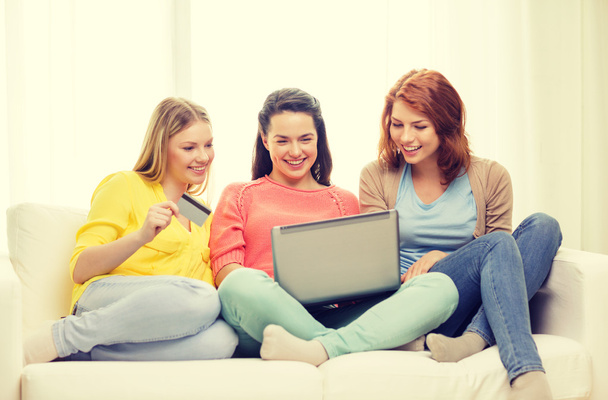 smiling teenage girls with laptop and credit card - Fotó, kép