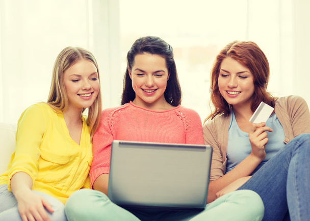smiling teenage girls with laptop and credit card - Фото, зображення