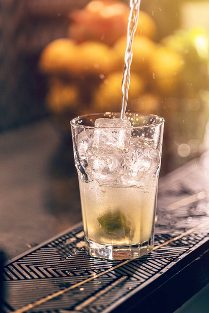 Bartender making a mojito cocktail, pours strong alcohol. Long drink concept - Fotó, kép