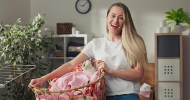 Portrait of woman working at home, girl holds wicker basket with clothes for washing, loading washing machine, hanging wet things on dryer, housekeeping. - Footage, Video
