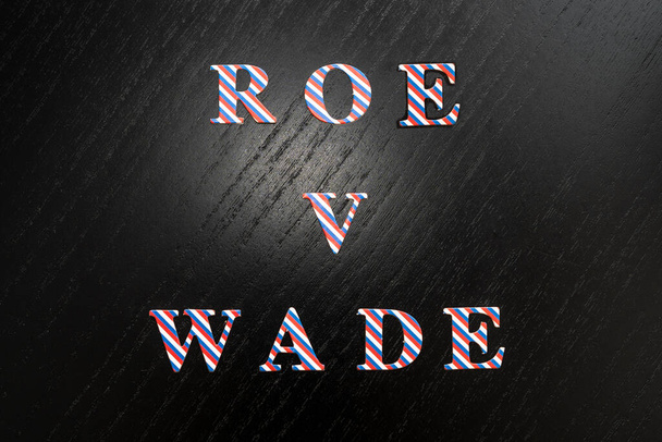 Roe V Wade. Proceso de aborto Roe contra Wade símbolo. Palabras conceptuales Roe V Wade, letras de colores de la bandera estadounidense sobre fondo negro de madera. - Foto, imagen