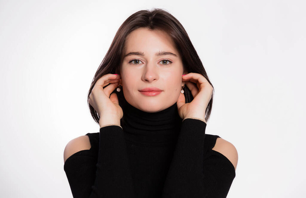 Woman with short hair and clean skin. Face close up, skin beauty tanned, beautiful smile woman in black turtleneck over white background - Foto, afbeelding